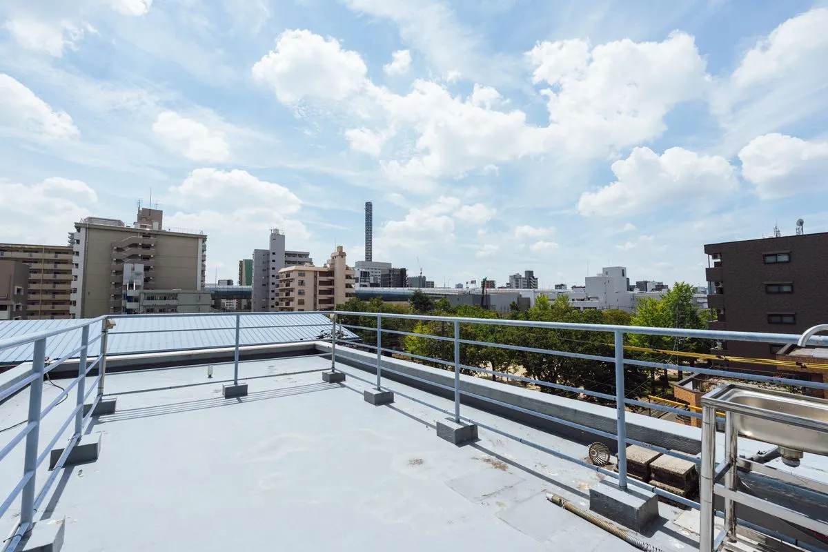 手すりの向こうに広がる街並みと青空